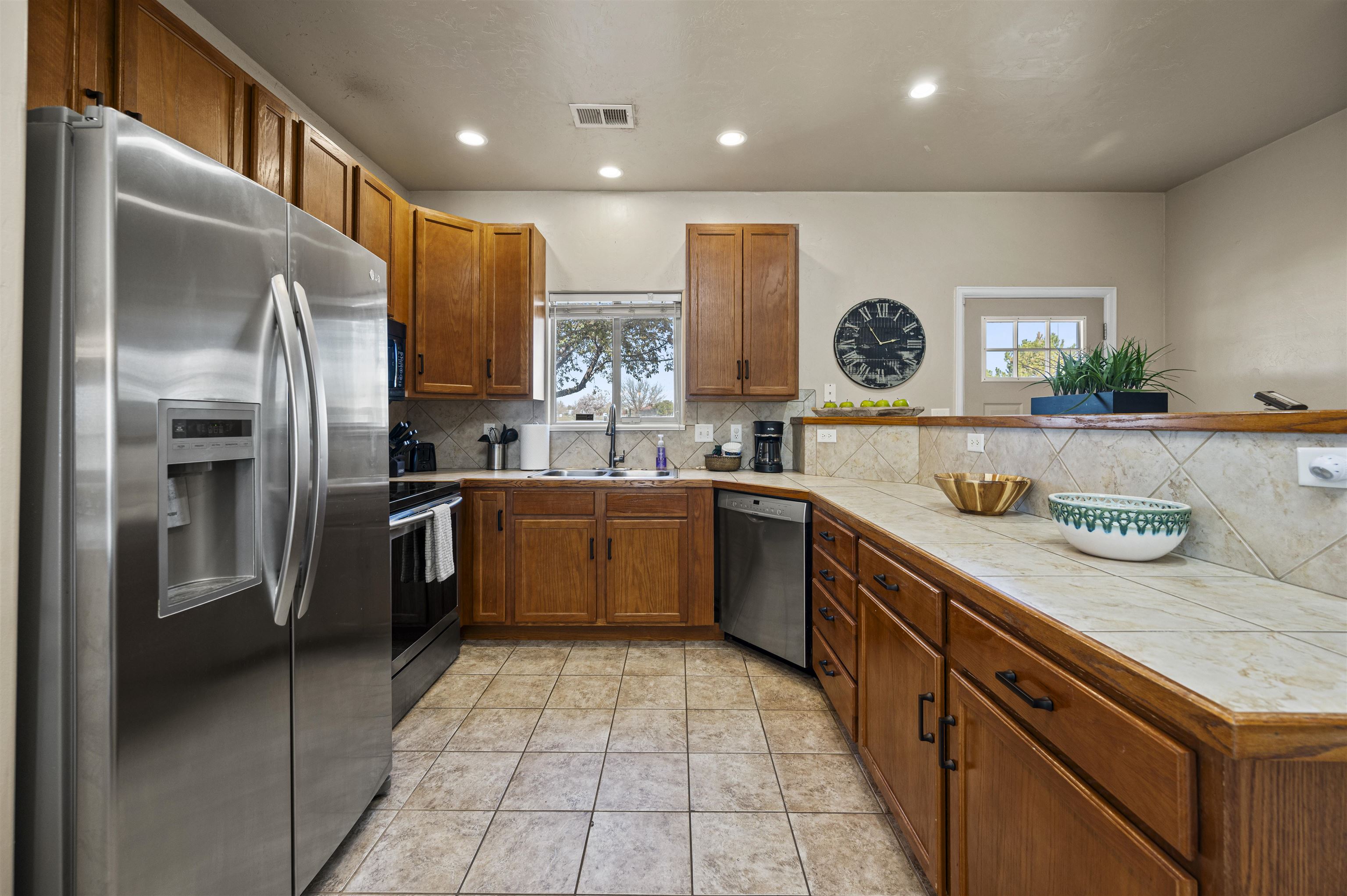 2436 1/2 Jack Creek Road Grand Junction, CO 81505 - Photo 7 of 36 a large kitchen with stainless steel appliances kitchen island granite countertop a refrigerator and a sink