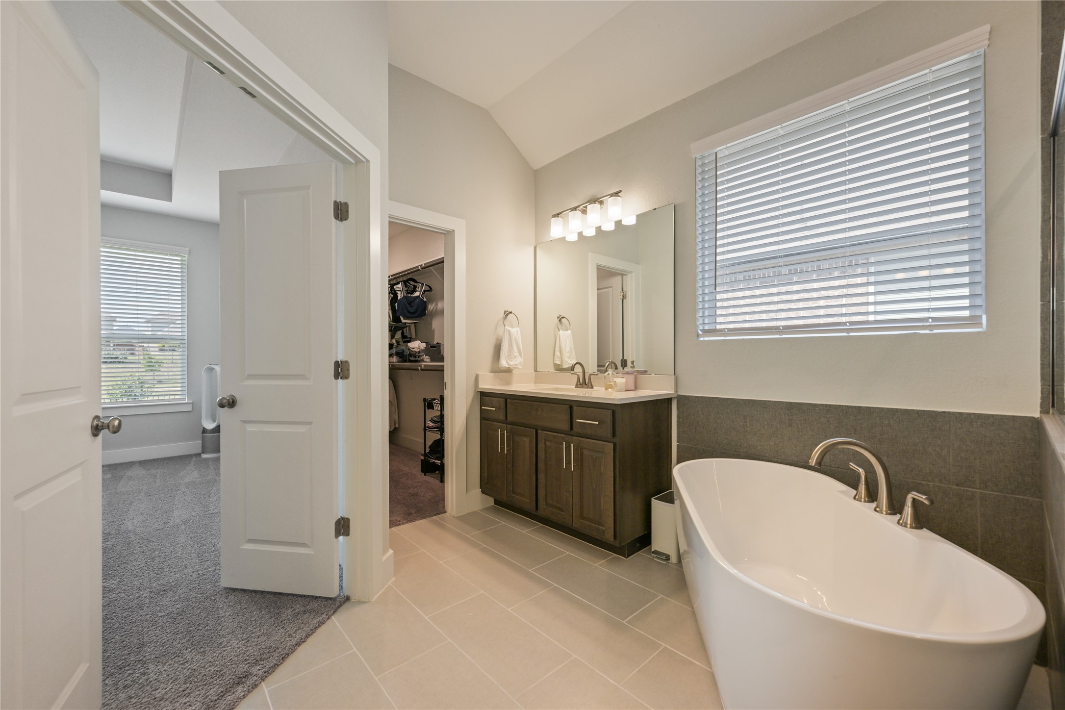 238 Wild Pecan Loop Buda, TX 78610 - Photo 17 of 31 Tiled flooring and a modern freestanding tub highlight this main bath layout.