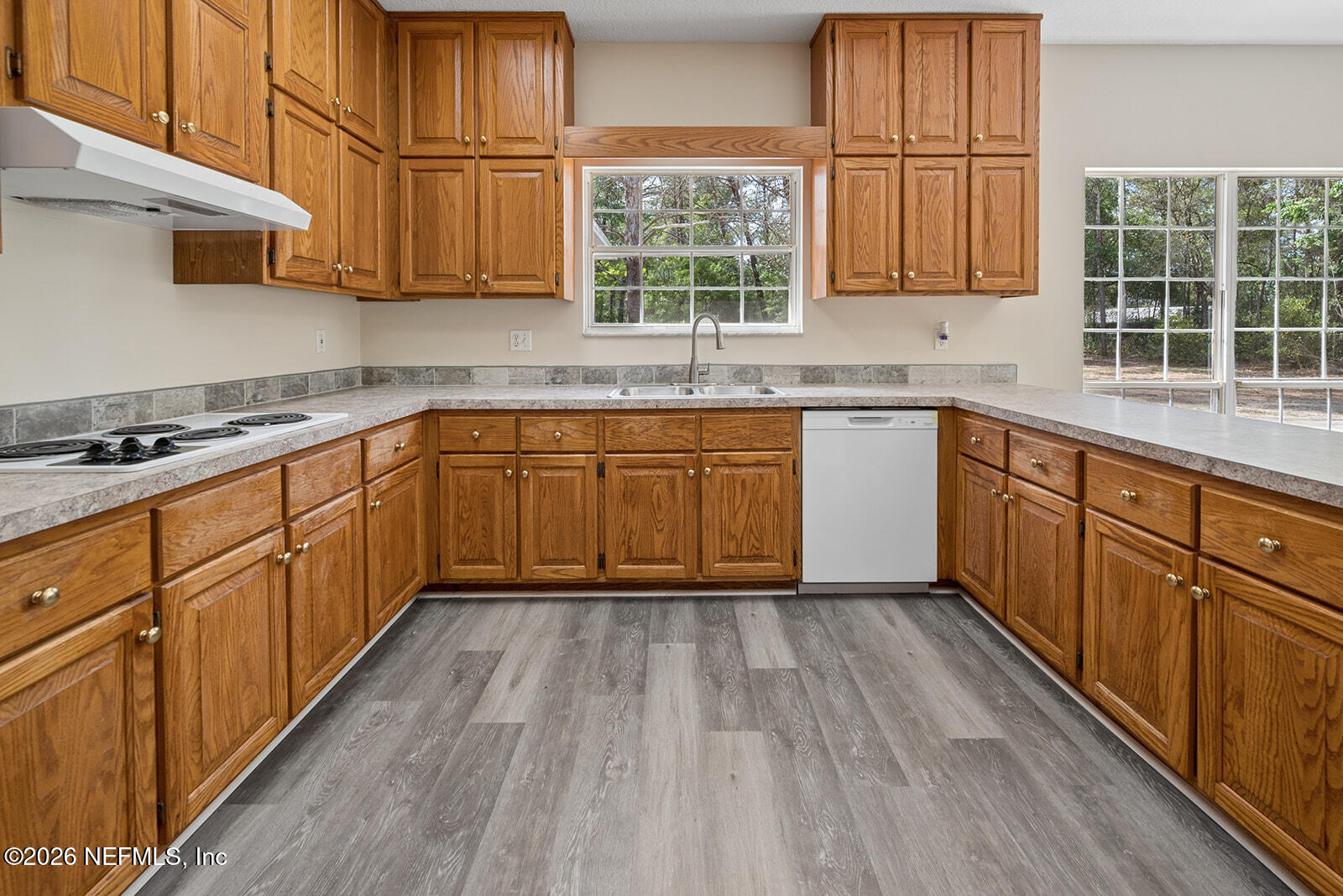 6240 Payne Road Keystone Heights, FL 32656 - Photo 19 of 43 a kitchen with wooden floors wooden cabinets a sink and a window