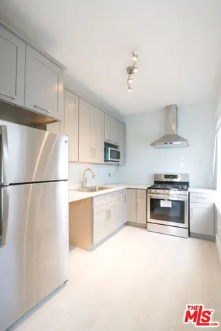 a kitchen with granite countertop a refrigerator and a stove top oven