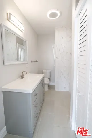 a bathroom with a sink a toilet and a mirror