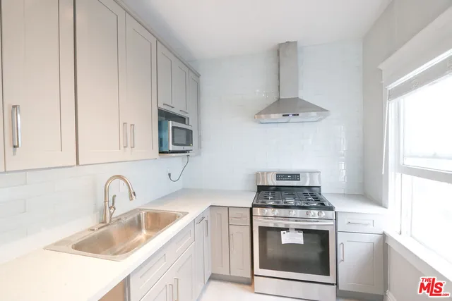a kitchen with stainless steel appliances granite countertop a sink stove and cabinets