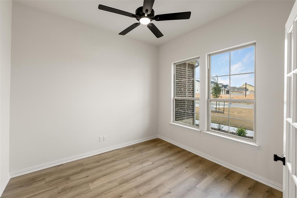 125 Snowy Owl Trail Rhome, TX 76078 - Photo 5 of 28 Empty room with light wood finished floors and a ceiling fan