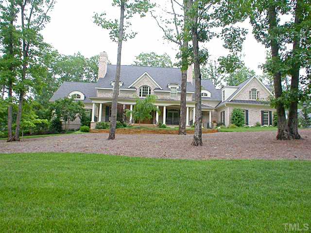 a front view of a house with a yard and green space