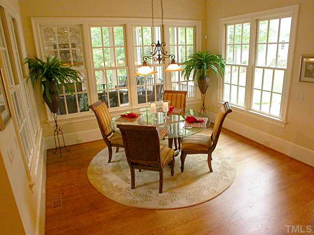 3032 Cone Manor Lane Raleigh, NC 27613 - Photo 5 of 12 a dining room with furniture floor to ceiling windows and potted plants