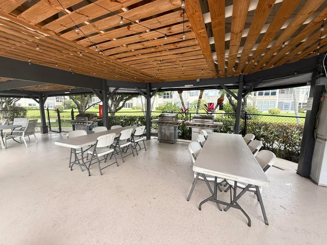 a view of a patio with table and chairs potted plants and large tree