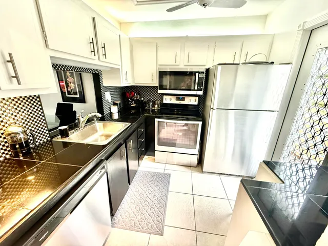 a kitchen with stainless steel appliances a refrigerator sink and stove