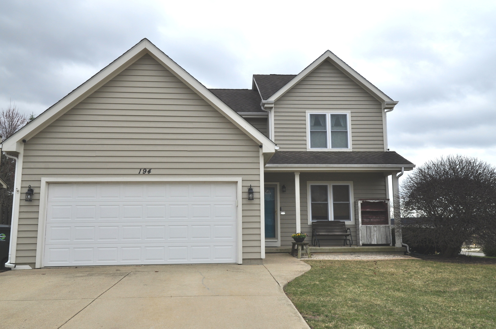 a view of a house with a yard and large tree