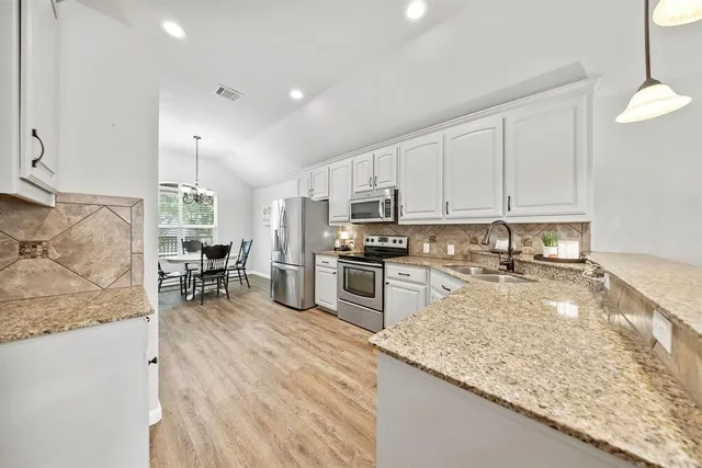 a kitchen with a stove a sink and a refrigerator