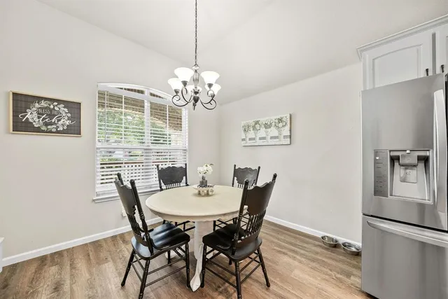 a view of a dining room with furniture a chandelier and wooden floor