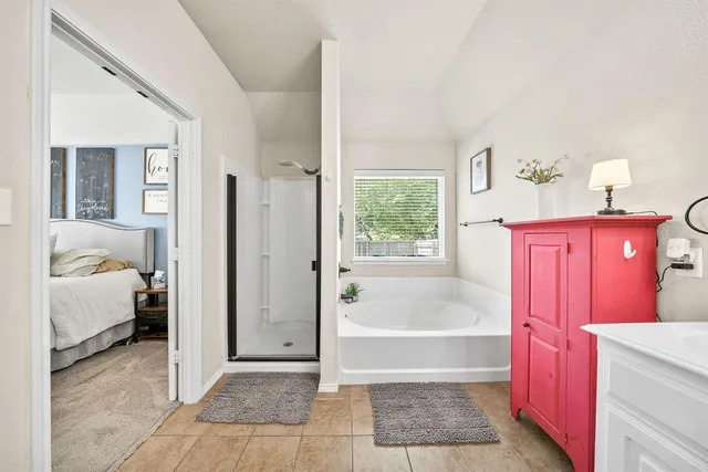 a bathroom with a tub shower and bedroom view