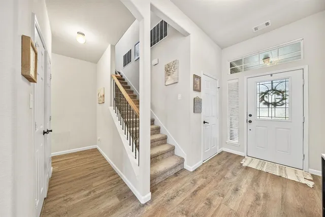 a view of a hallway with wooden floor and entryway