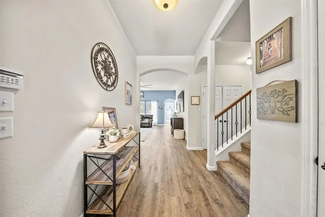 a view of a hallway with wooden floor and windows