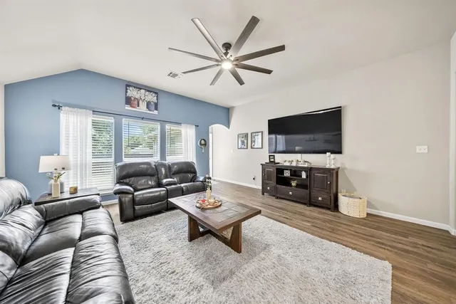 a living room with furniture a flat screen tv and a window