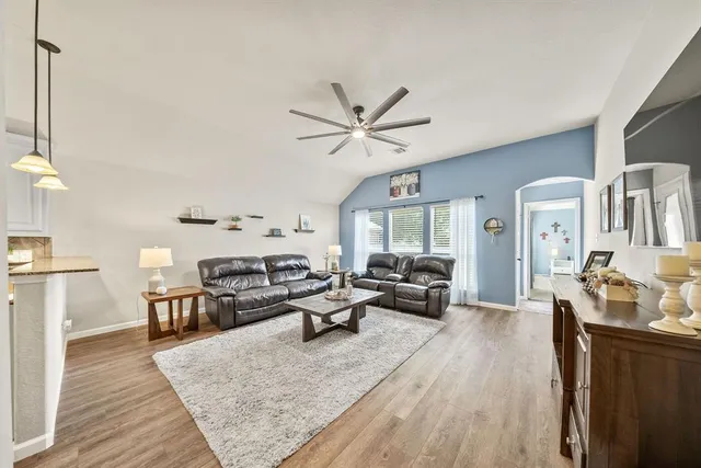 a living room with furniture and a wooden floor