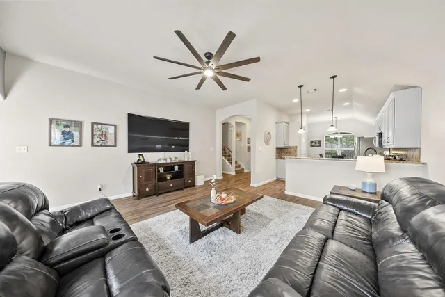 a living room with furniture a flat screen tv and kitchen view