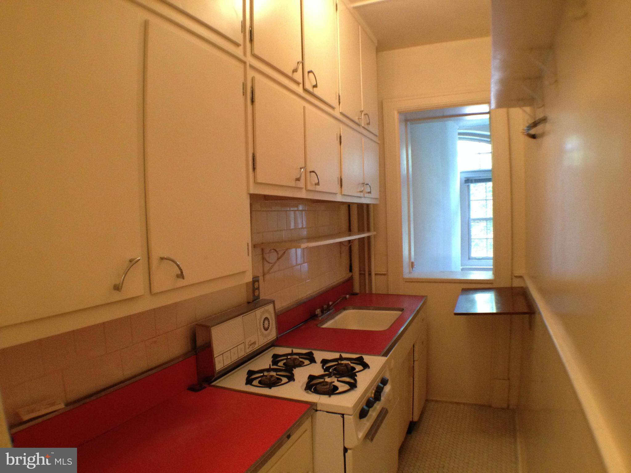 501 West University Parkway, Unit C1 Baltimore, MD 21210 - Photo 11 of 29 a kitchen with granite countertop a stove and a refrigerator