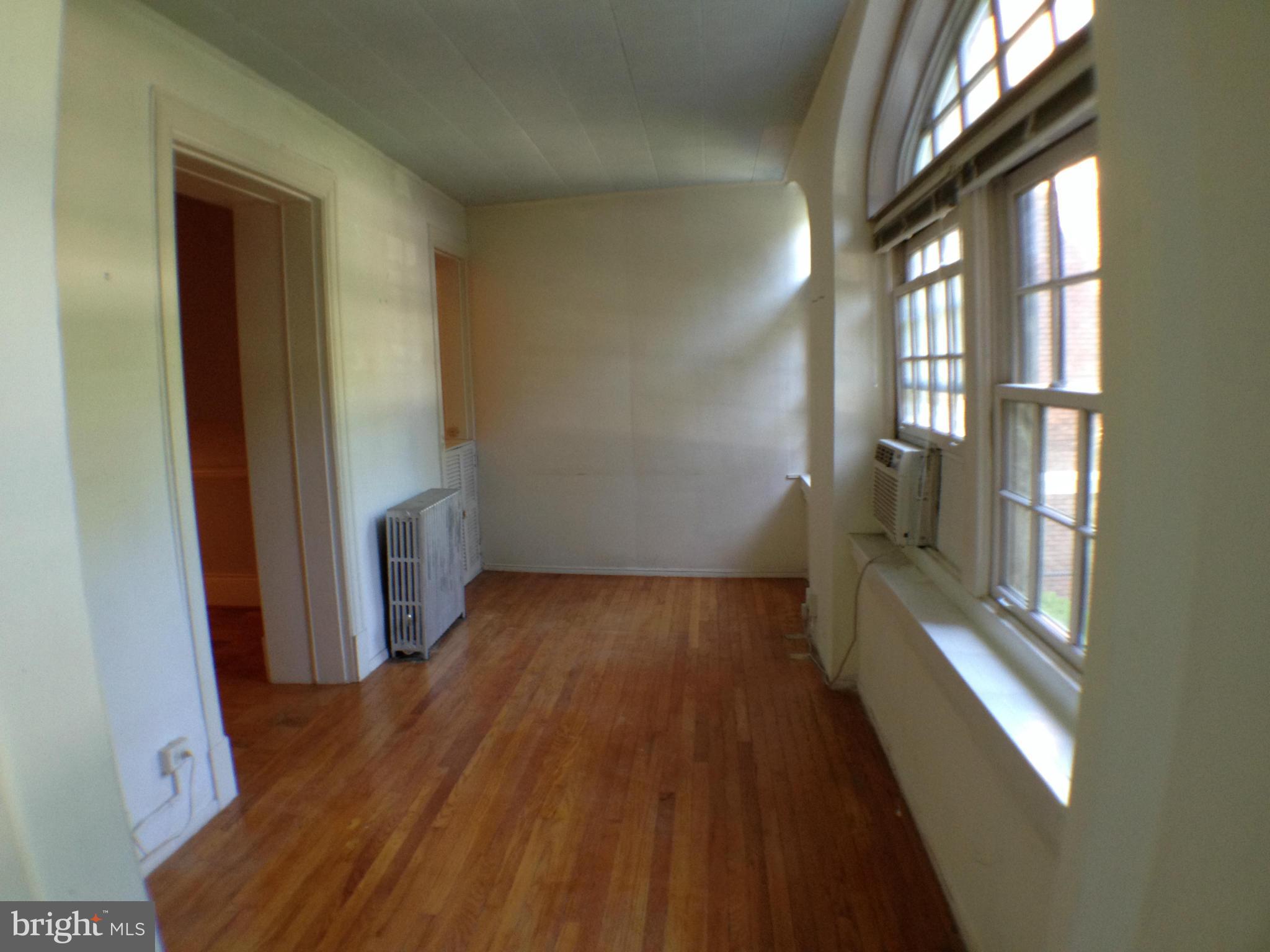 501 West University Parkway, Unit C1 Baltimore, MD 21210 - Photo 16 of 29 wooden floor in an empty room with a window