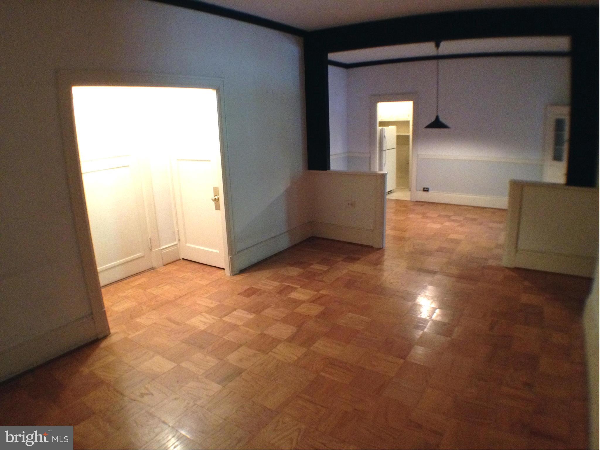 501 West University Parkway, Unit C1 Baltimore, MD 21210 - Photo 6 of 29 a view of a hallway with wooden floor and a cabinet