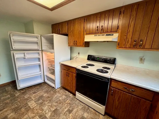 a kitchen with granite countertop a refrigerator and a stove