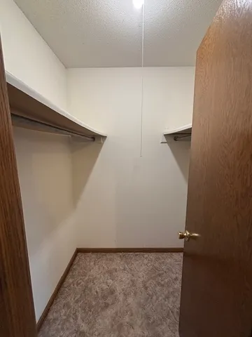 a view of a hallway with wooden floor and closet