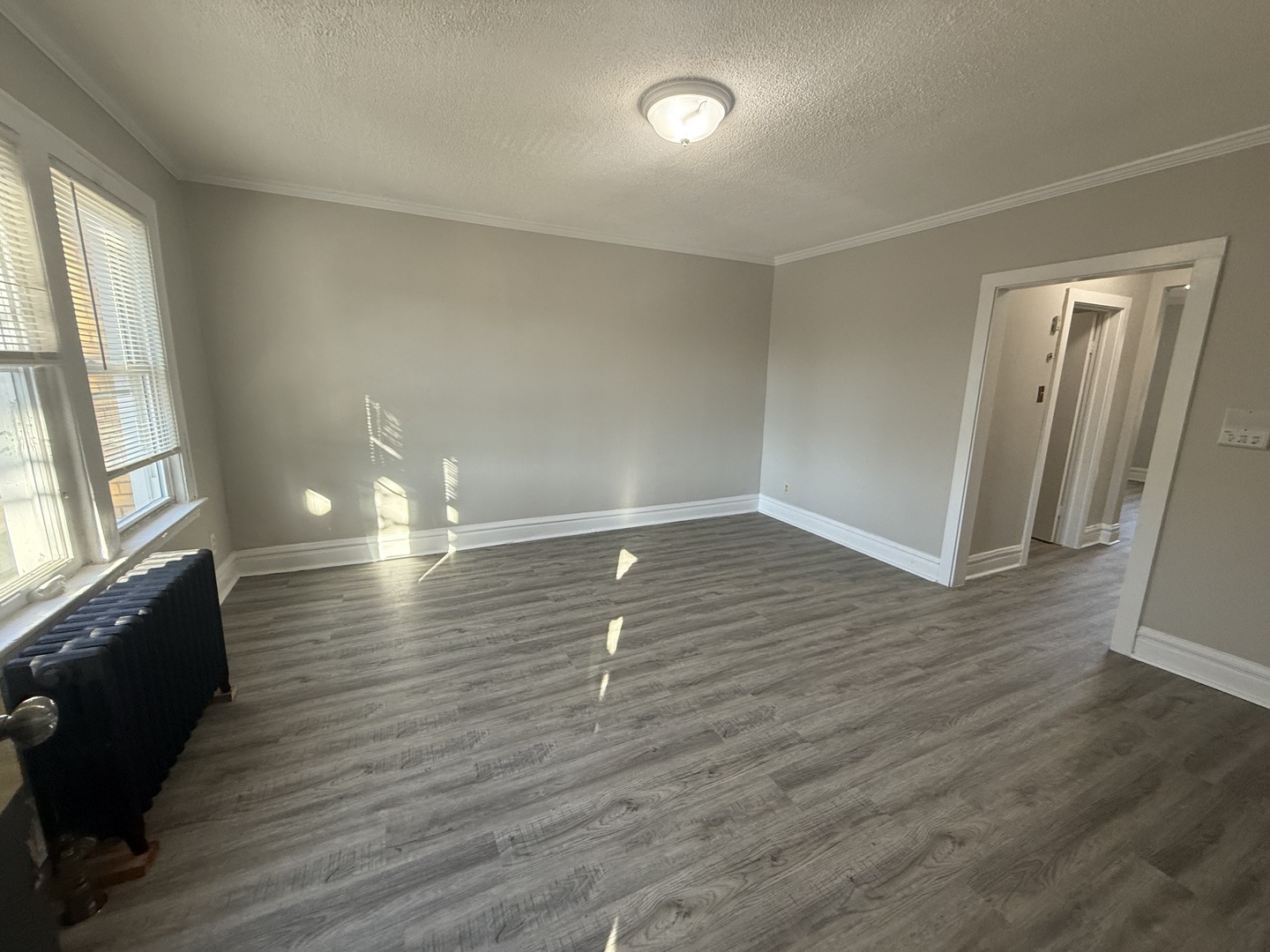 6443 23rd Street, Unit 12 Berwyn, IL 60402 - Photo 3 of 9 an empty room with wooden floor and windows