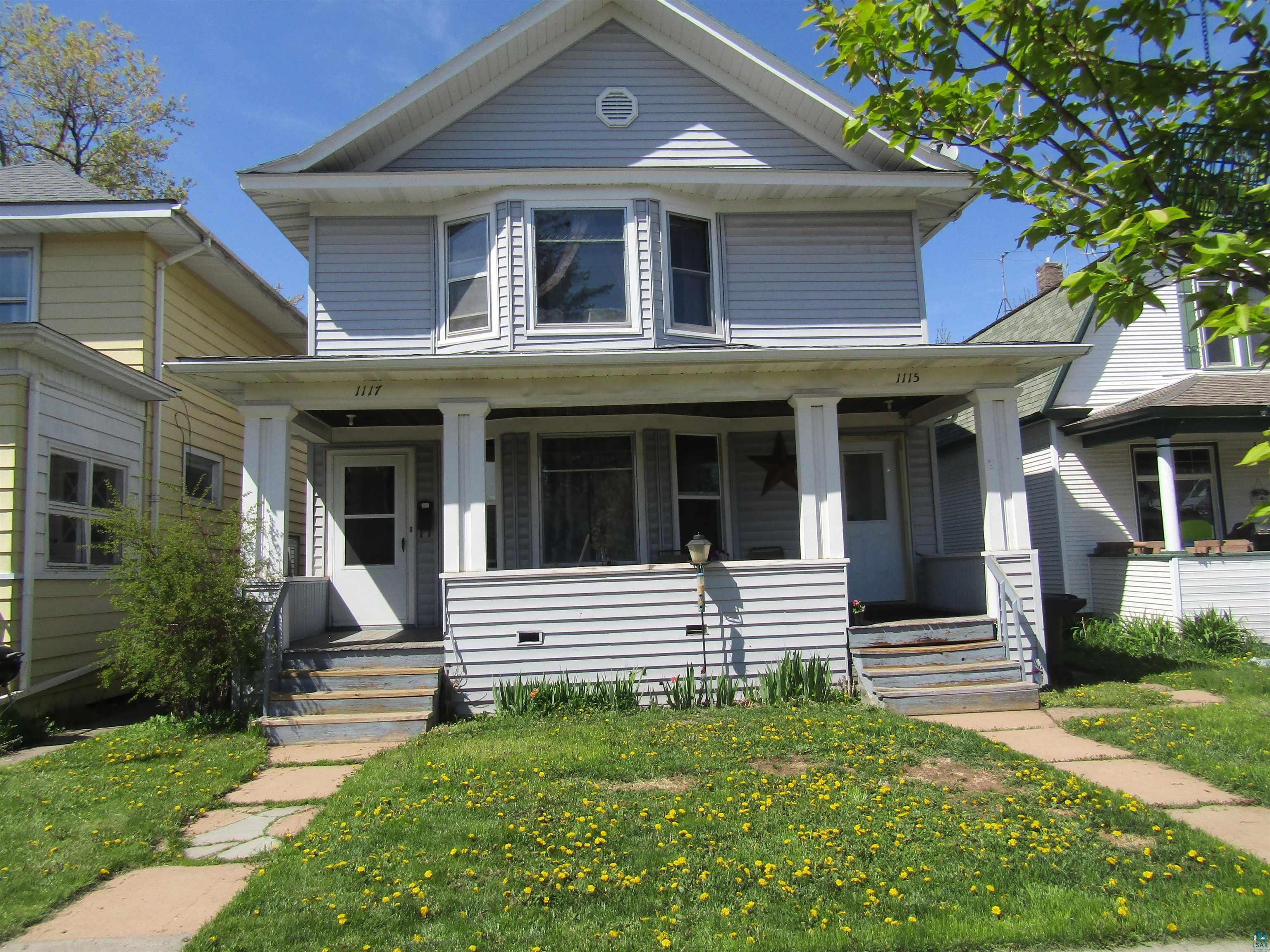 1115 Harrison Street Superior, WI 54880 - Photo 1 of 49 Two-story property featuring light blue horizontal siding and a prominent bay window