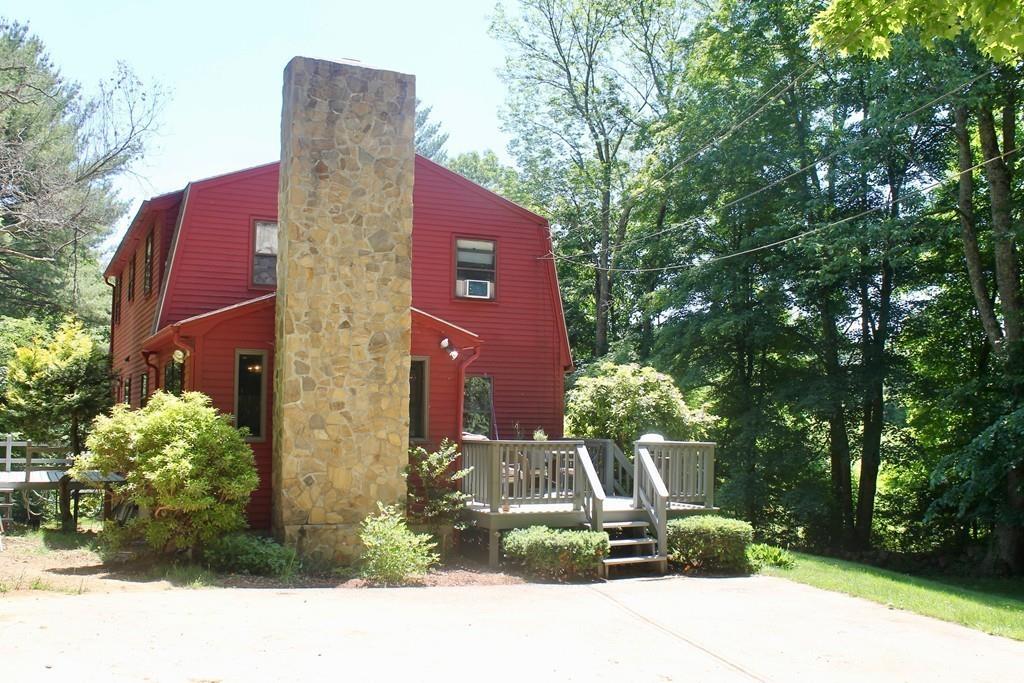 1887 North Brookfield Road Oakham, MA 01068 - Photo 2 of 23 a car parked in front of a brick building with large trees