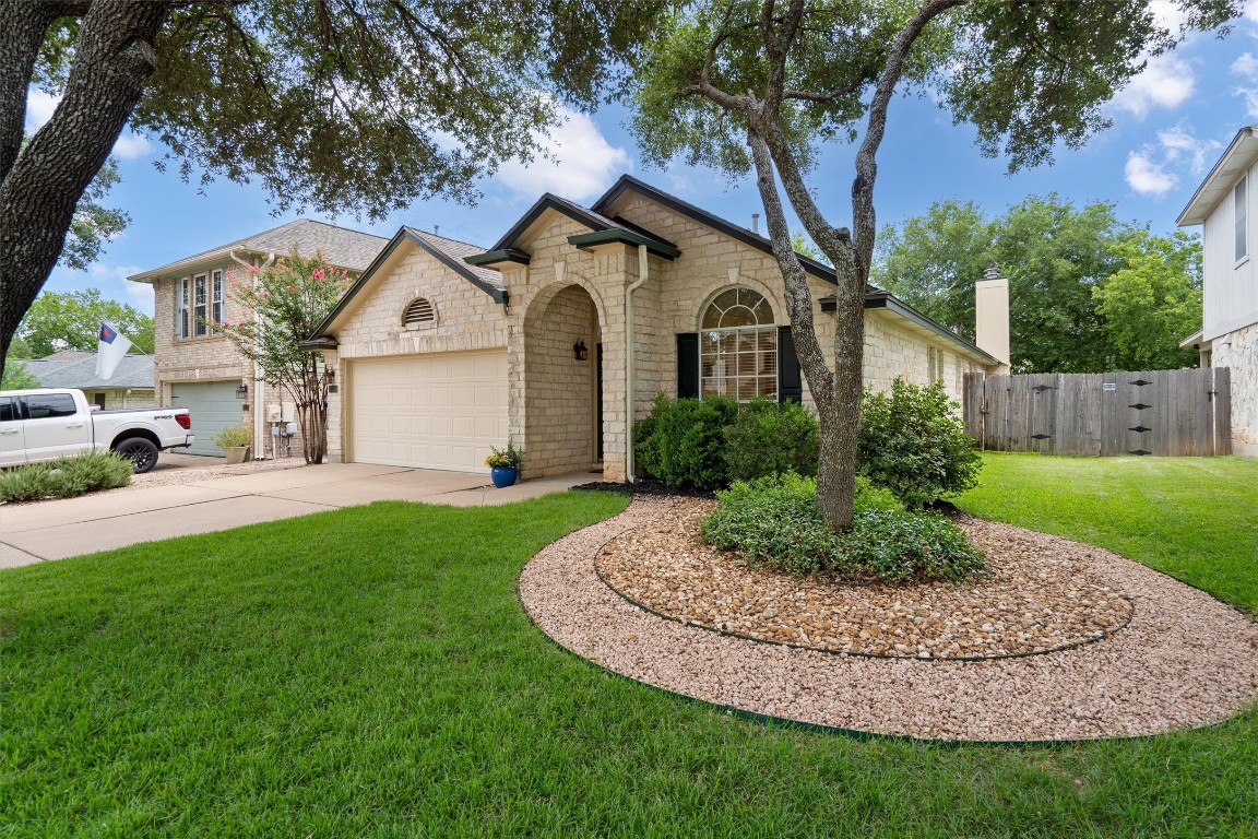 a view of a white house with a big yard and potted plants