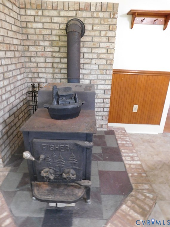 838 Crymes Road Keysville, VA 23947 - Photo 21 of 49 Detailed view of a wood stove, a wainscoted wall,