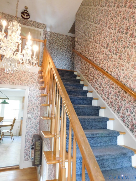838 Crymes Road Keysville, VA 23947 - Photo 24 of 49 Staircase with wallpapered walls, a chandelier, an