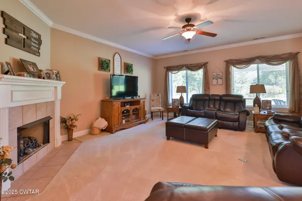 a living room with furniture a fireplace and a flat screen tv