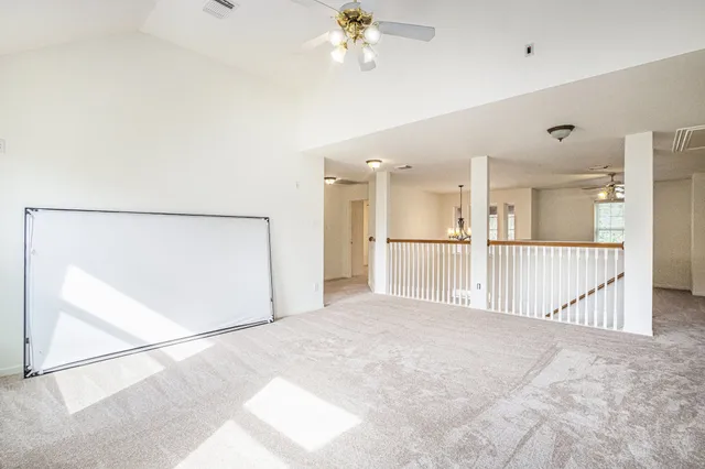a view of a hallway with a chandelier fan and refrigerator