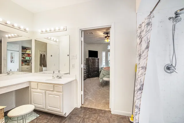 a en suite bathroom with a double vanity sink and a mirror