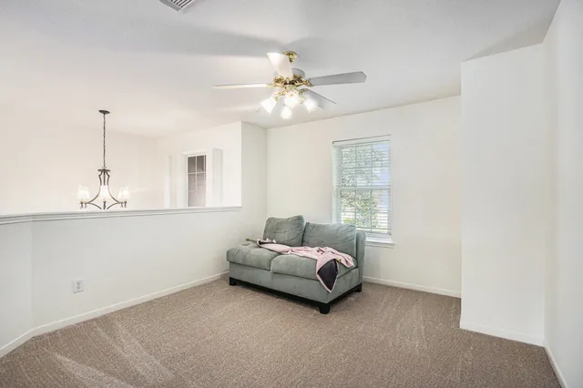 a living room with furniture and a ceiling fan