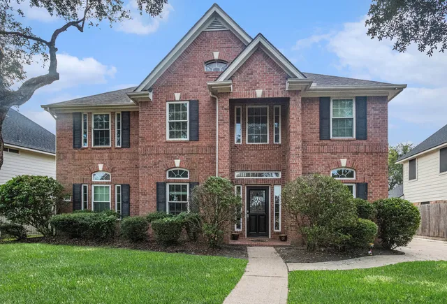 a front view of a house with a yard and potted plants