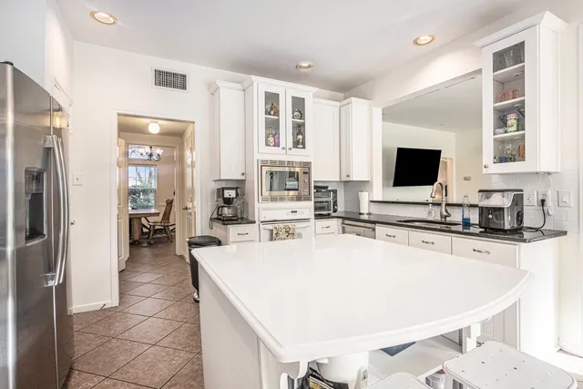 a large kitchen with a large counter top appliances and cabinets