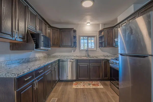 a kitchen with stainless steel appliances granite countertop a refrigerator and a sink