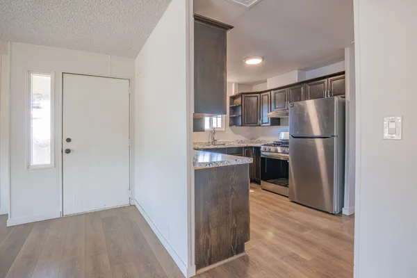 a kitchen with stainless steel appliances granite countertop a refrigerator and a sink