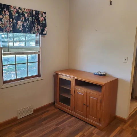 a kitchen with a wooden floor and a window