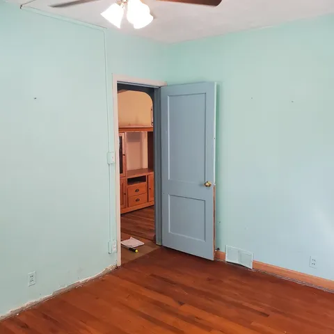 an empty room with closet and wooden floor