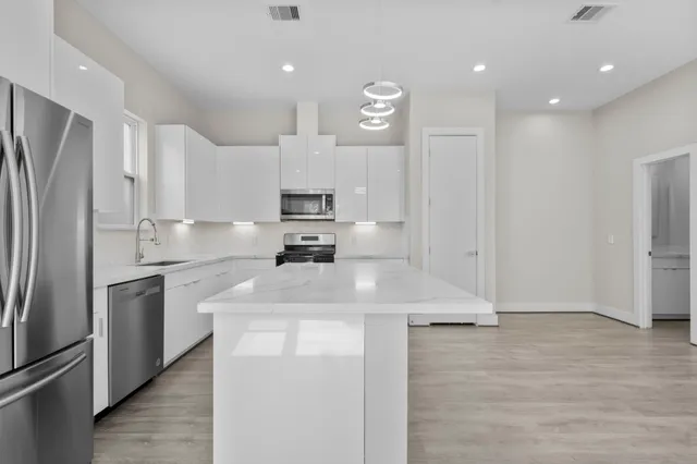a kitchen with stainless steel appliances granite countertop a stove a sink and a microwave