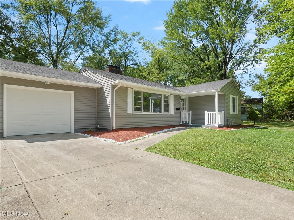 Single story home featuring a garage and a front yard
