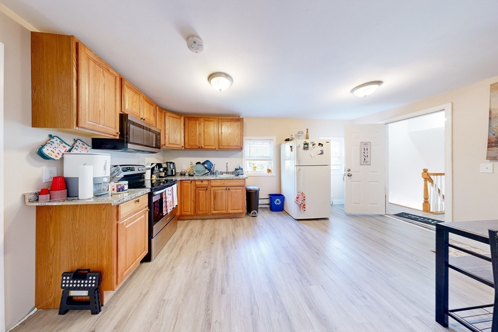 249 North Main Street Webster, MA 01570 - Photo 13 of 32 a kitchen with stainless steel appliances granite countertop a refrigerator a stove top oven a sink dishwasher and white cabinets with wooden floor