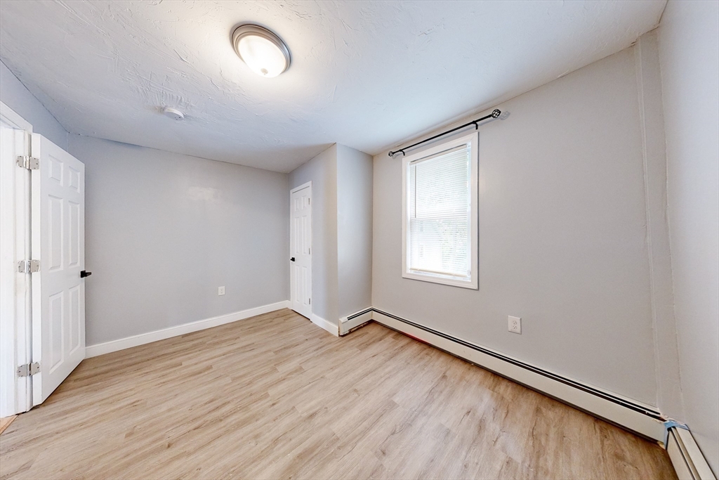 249 North Main Street Webster, MA 01570 - Photo 8 of 32 an empty room with wooden floor and windows