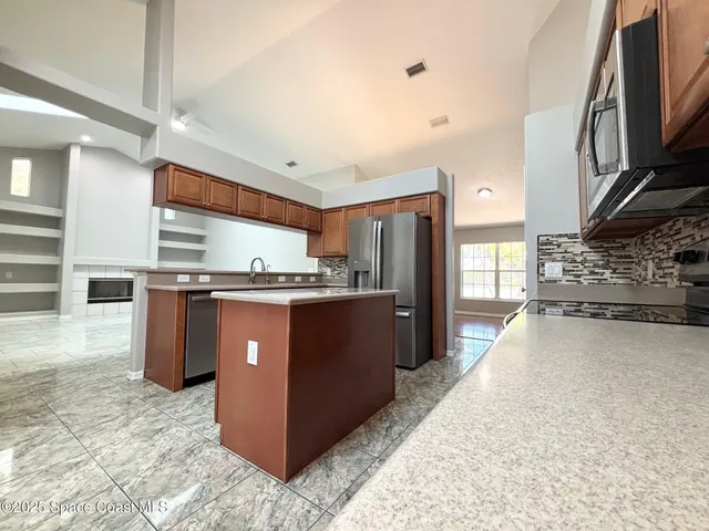 a kitchen with stainless steel appliances granite countertop a stove a refrigerator and a oven