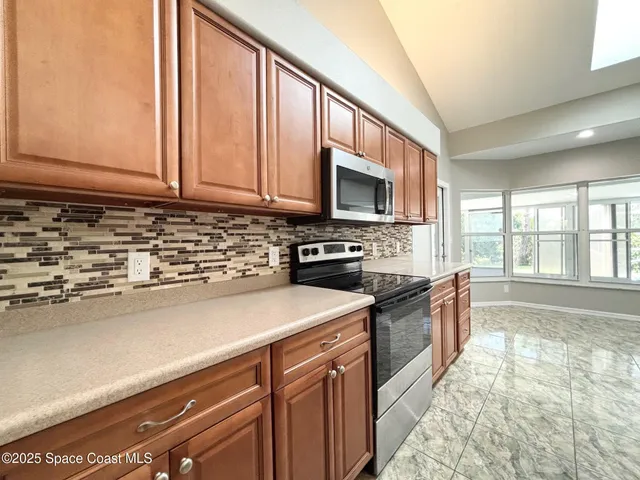 a kitchen with stainless steel appliances granite countertop a sink a stove a microwave a sink and cabinets
