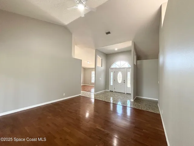 a view of an empty room with a fireplace and wooden floor