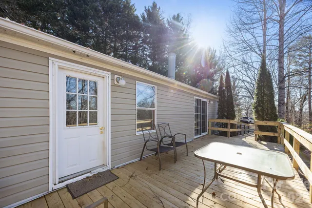 a view of a patio with table and chairs with wooden floor and fence