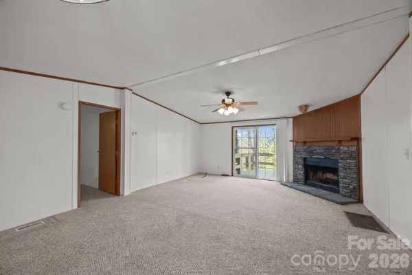 a view of empty room with fireplace and fan